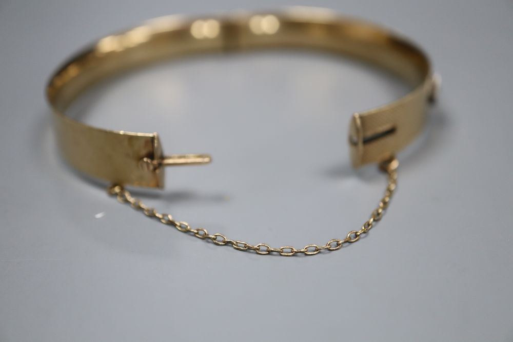 A 9ct and bronze core hinged bangle set with four diamonds and a cabochon stone.